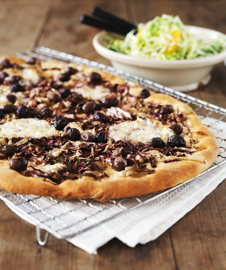Pizza topped with red onions, goat's cheese and olives