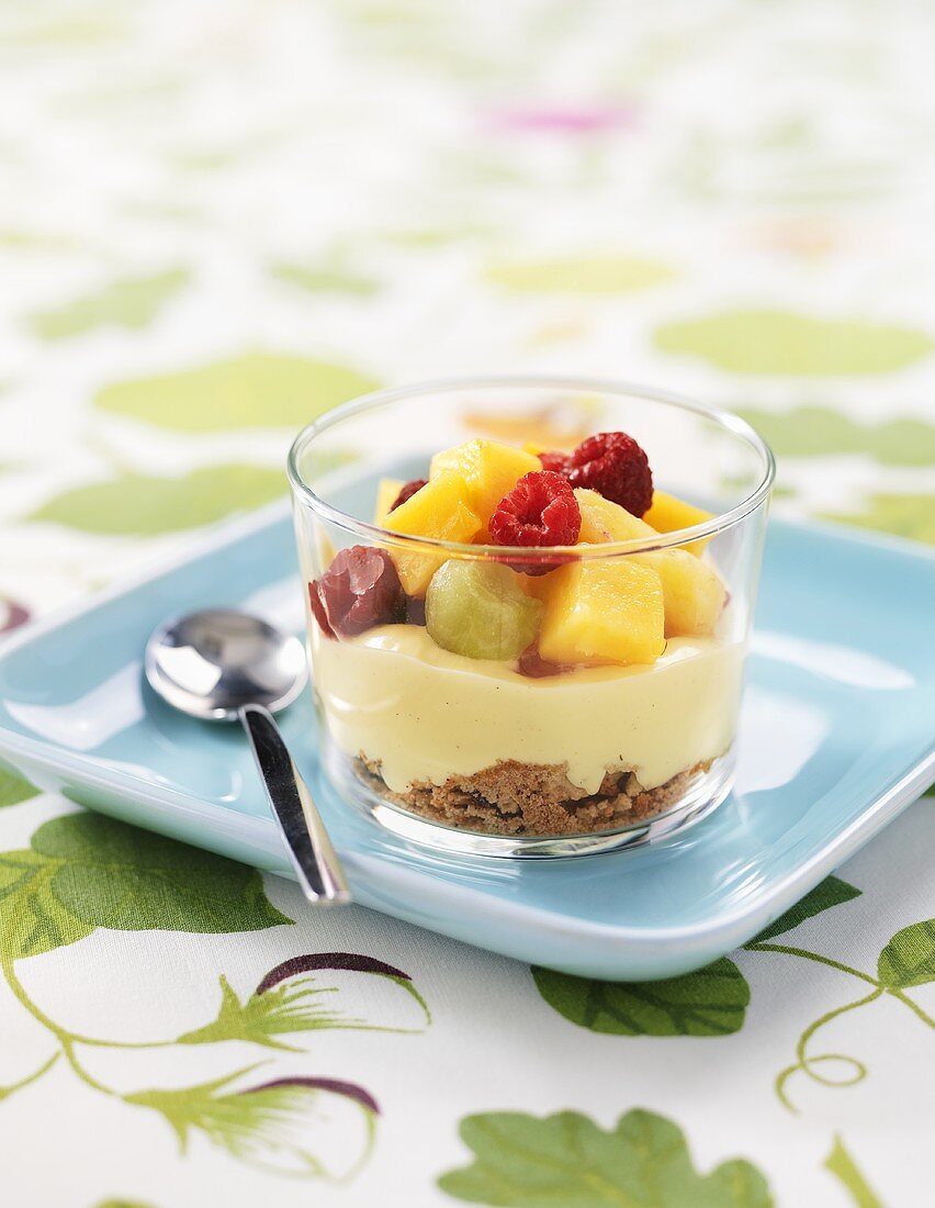 Crushed biscuits, custard and fruit in a glass
