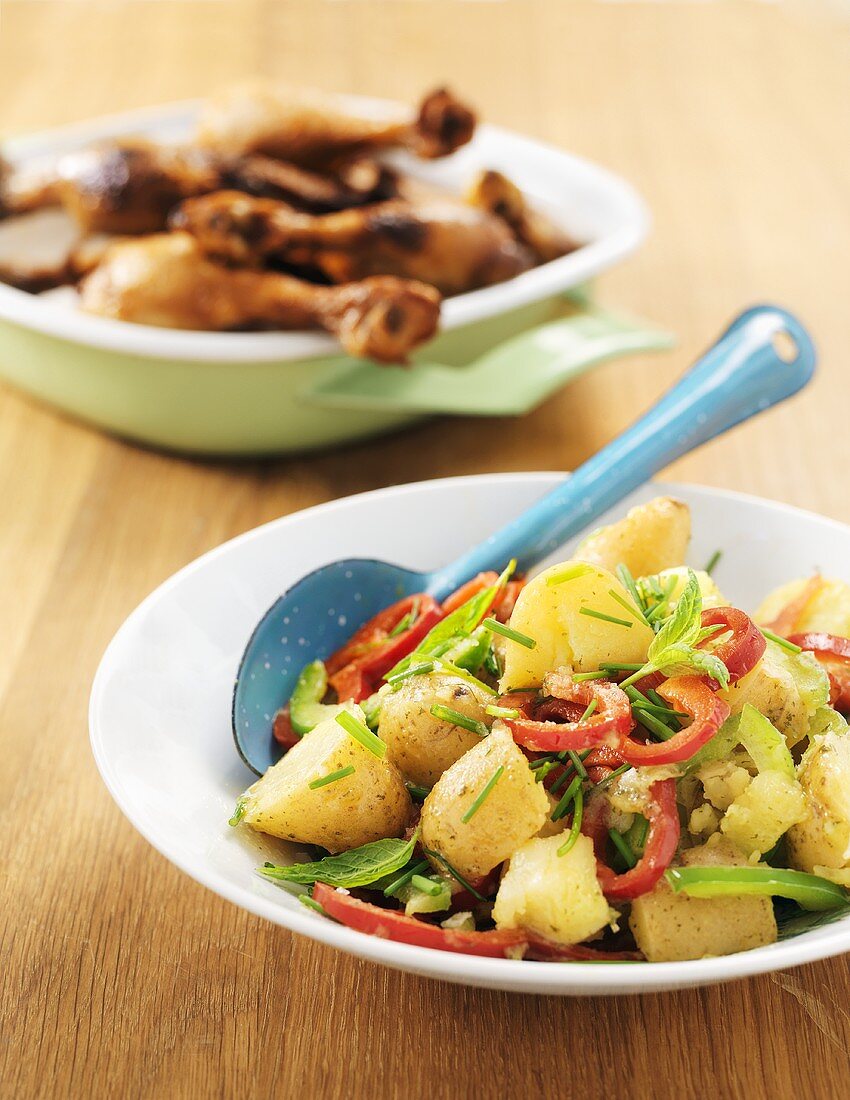 Grilled chicken drumsticks with warm potato & pepper salad