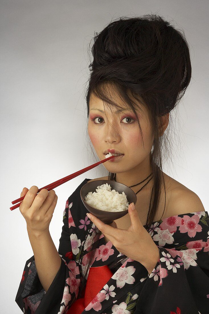 A Japanese woman eating rice out of a bowl