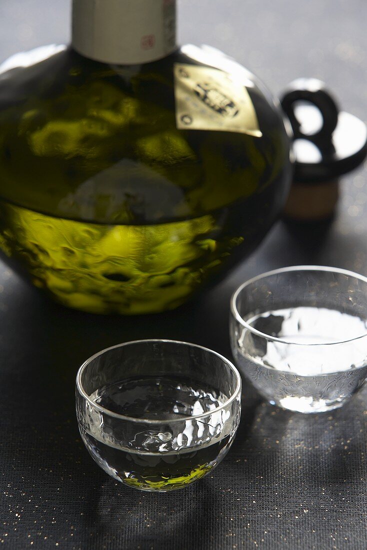 Sake in einer Glas-Karaffe und in zwei Gläsern