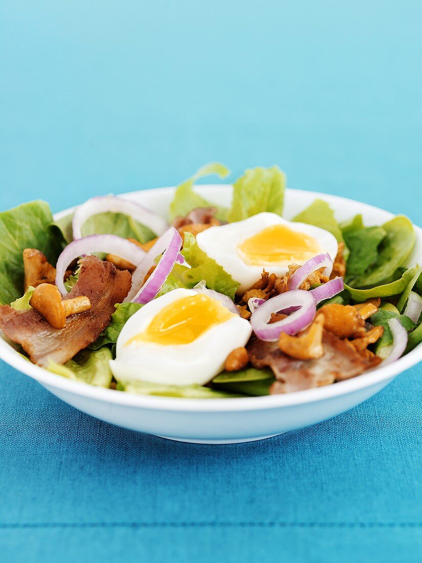 Salad leaves with bacon, chanterelles and boiled egg