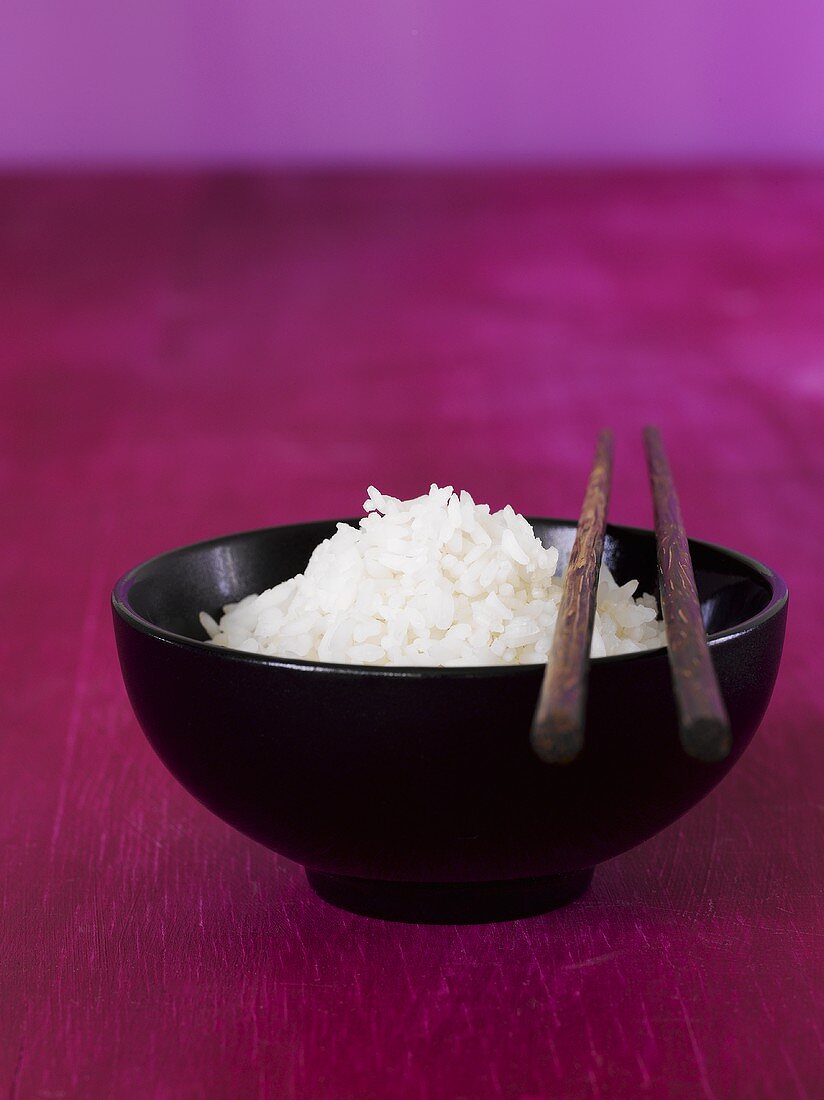 A bowl of rice with chopsticks