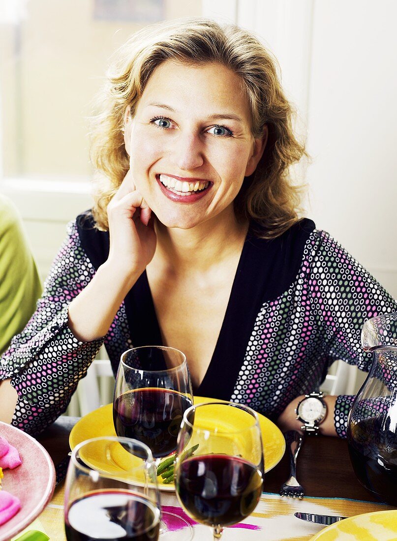 Young woman sitting at table laid for Easter