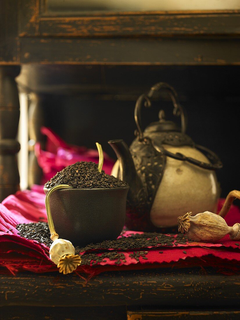 Black sesame seeds in a bowl with a teapot