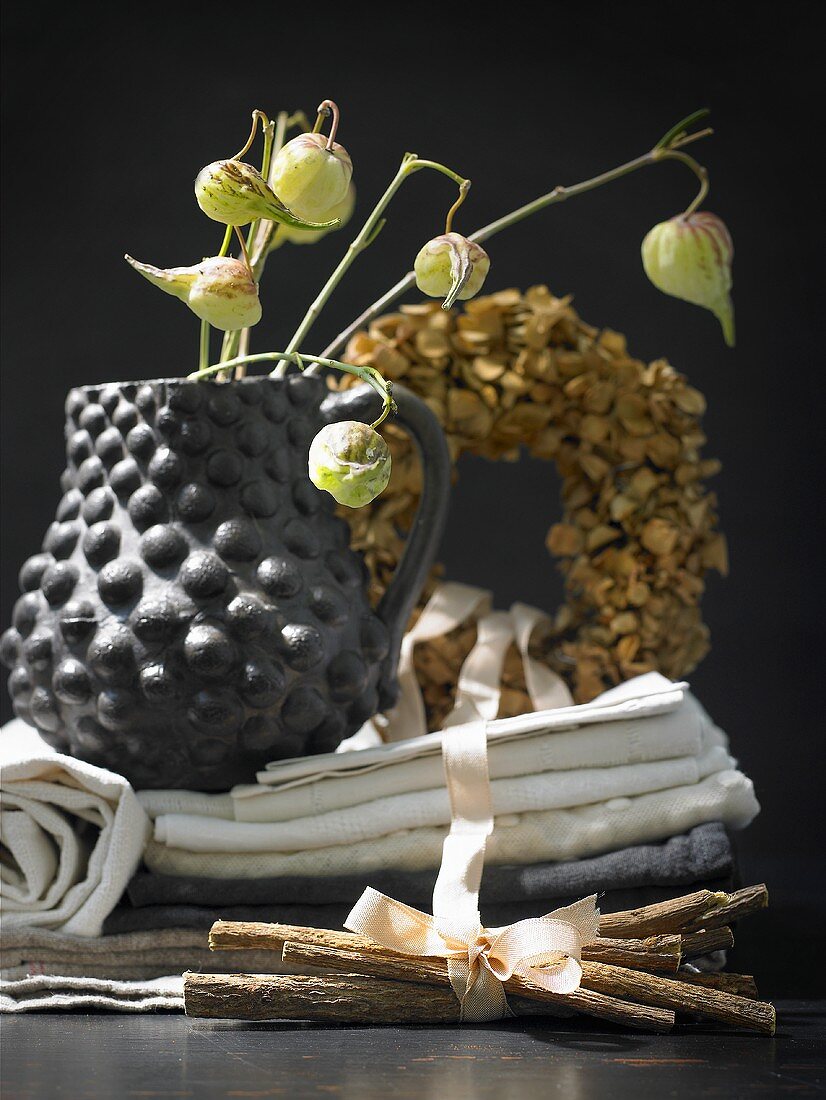 A bundle of liquorice roots in front of a pile of cloths