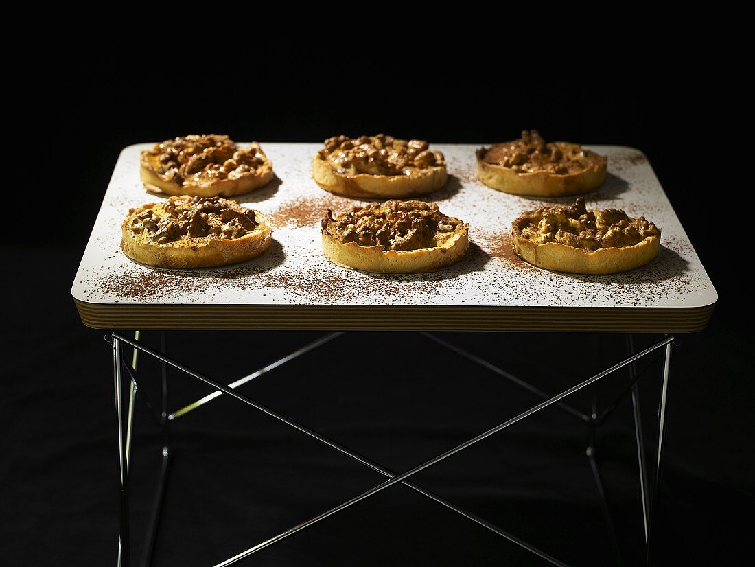 Six small nut tarts on an occasional table