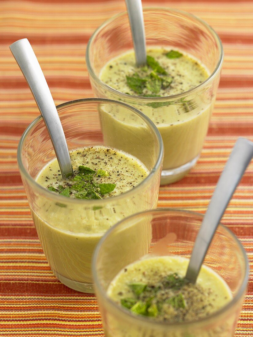 Three glasses of cucumber and coconut soup with mint