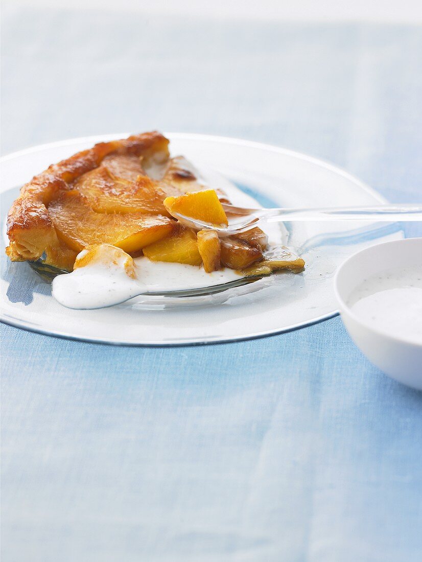 Ein Stück Pfirsich-Tarte tatin mit Joghurtcreme