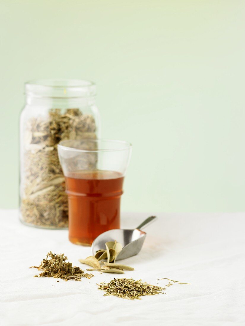 A glass of tea with various medicinal herbs