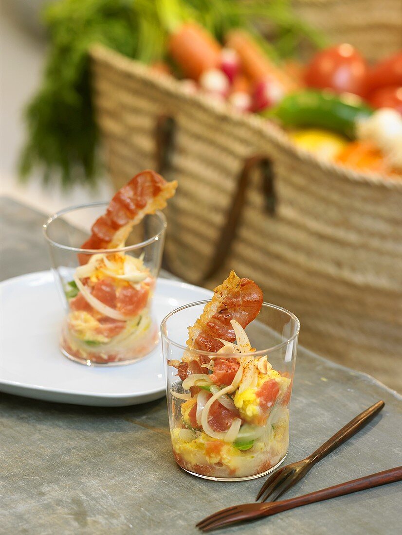 Piperade with fried bacon in two glasses