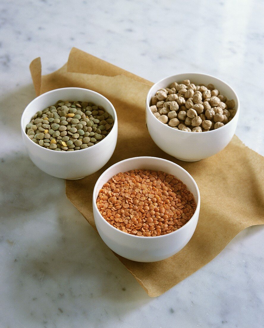 Dried green and red lentils and chick-peas in small bowls