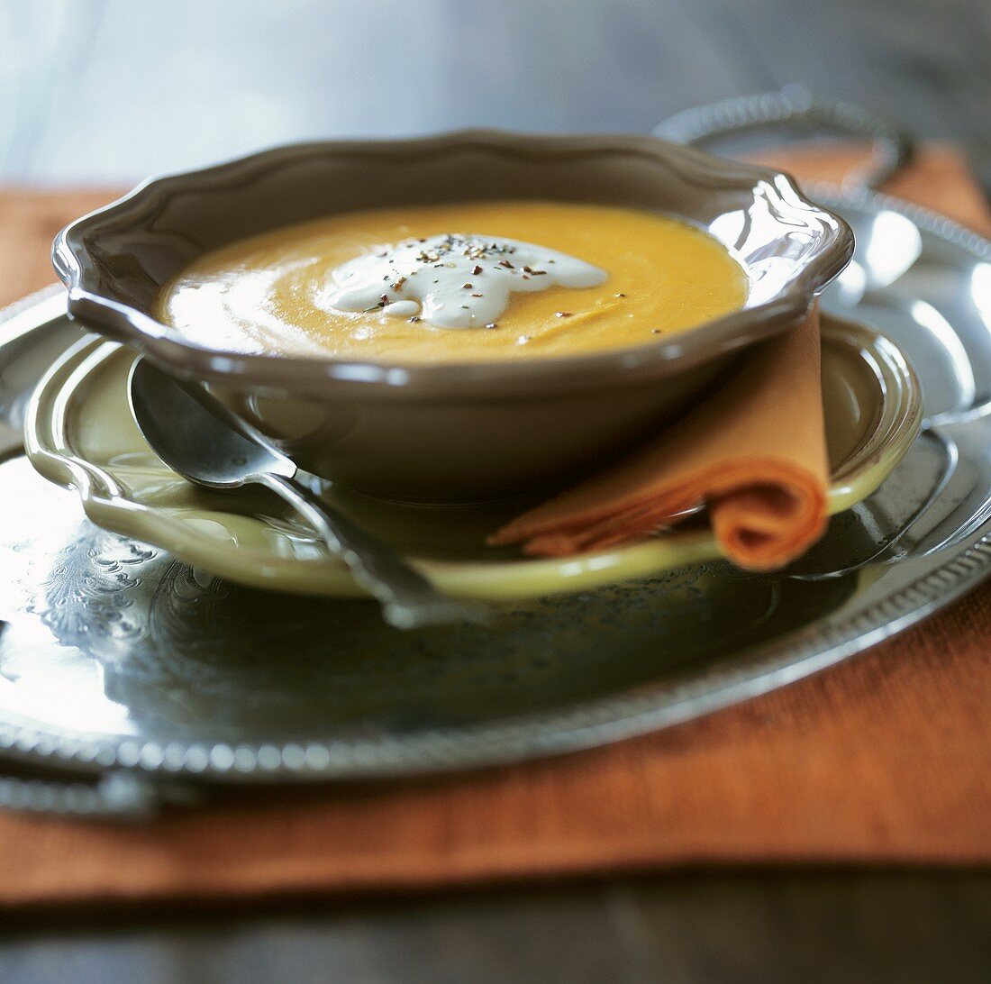 Kürbissuppe mit Sahneklecks und buntem Pfeffer