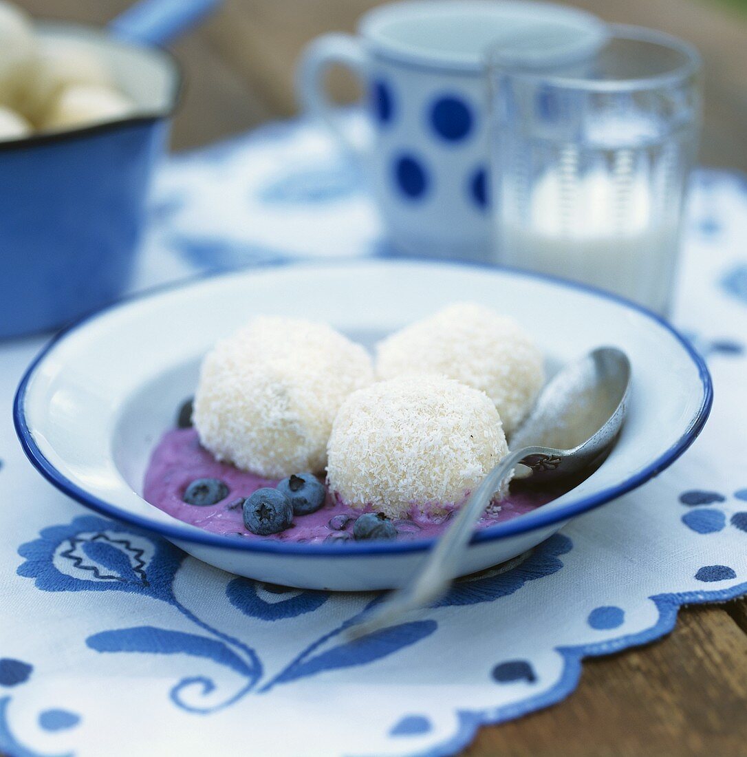 Blueberry and coconut dumplings on blueberry sauce