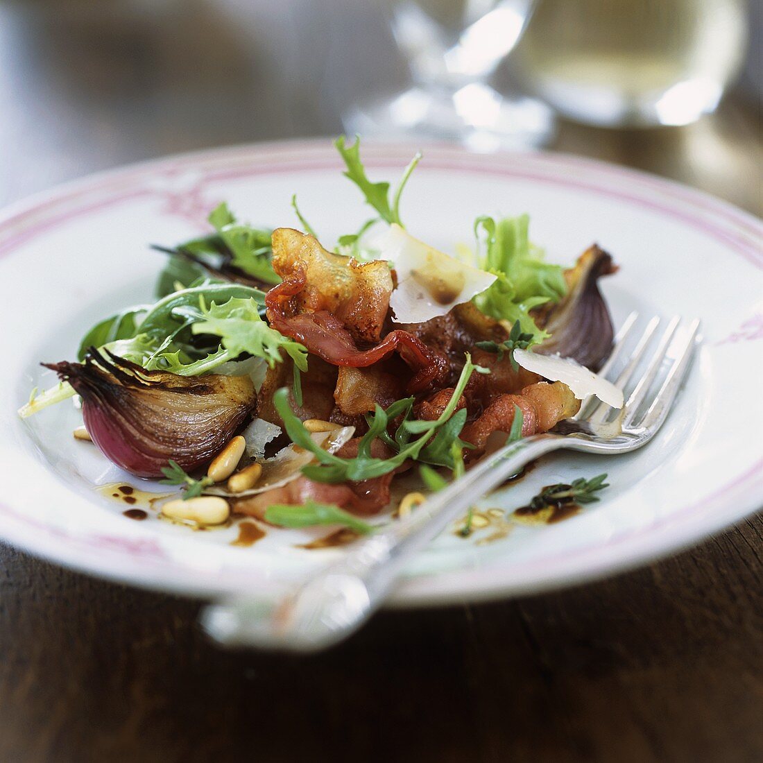 Rocket salad with bacon, onions and pine nuts