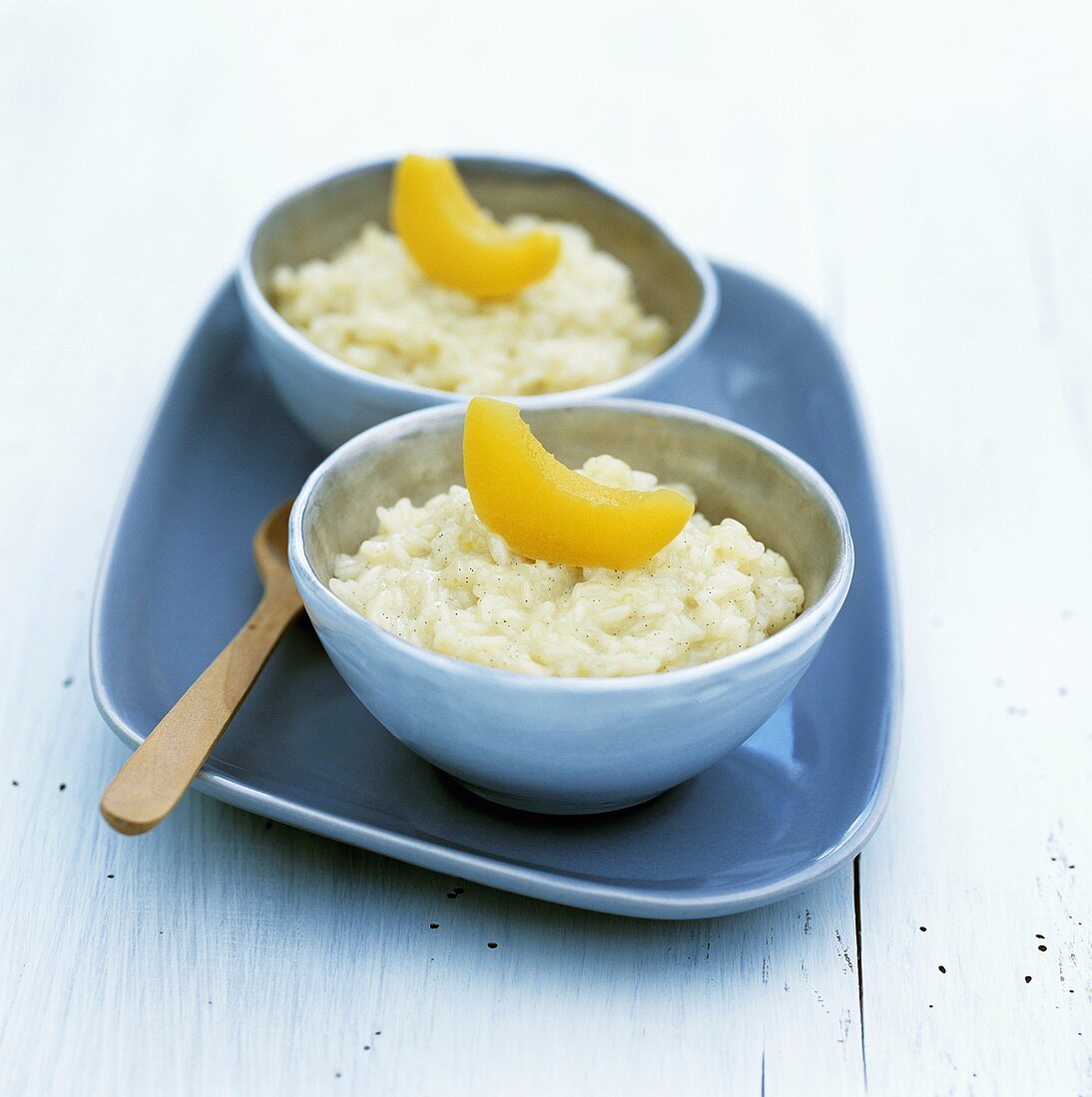 Two bowls of coconut rice pudding with peach
