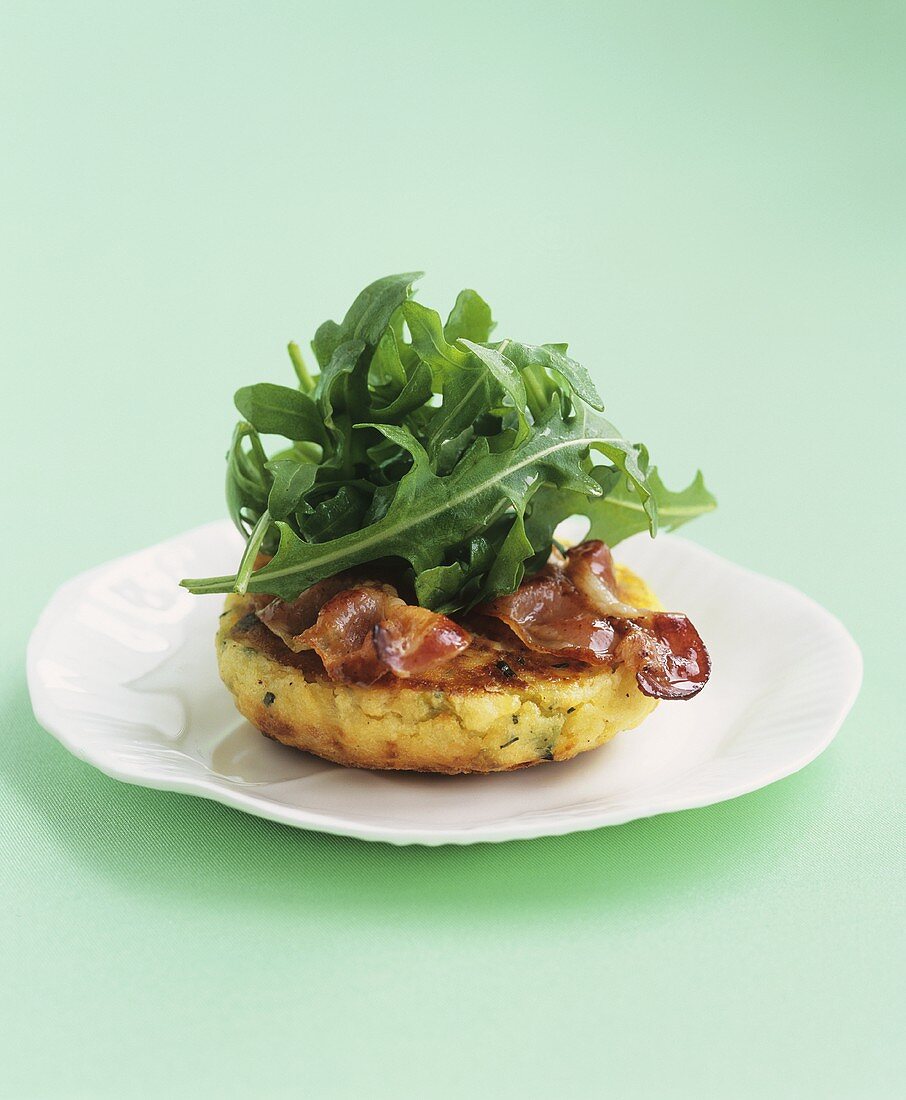 Cheese and potato cake with bacon and rocket