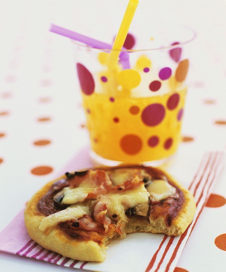 Mini-Pizza mit einem Glas Limonade