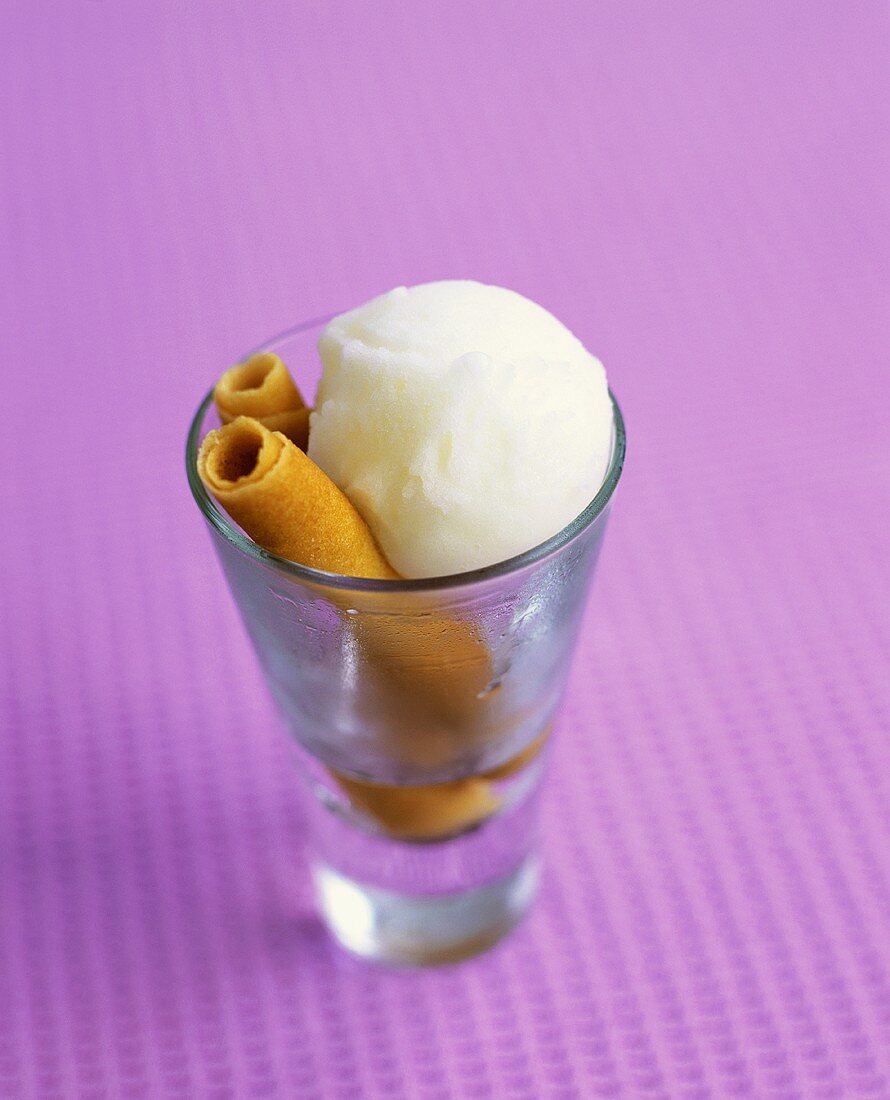 Lemon sorbet with wafer rolls in a glass