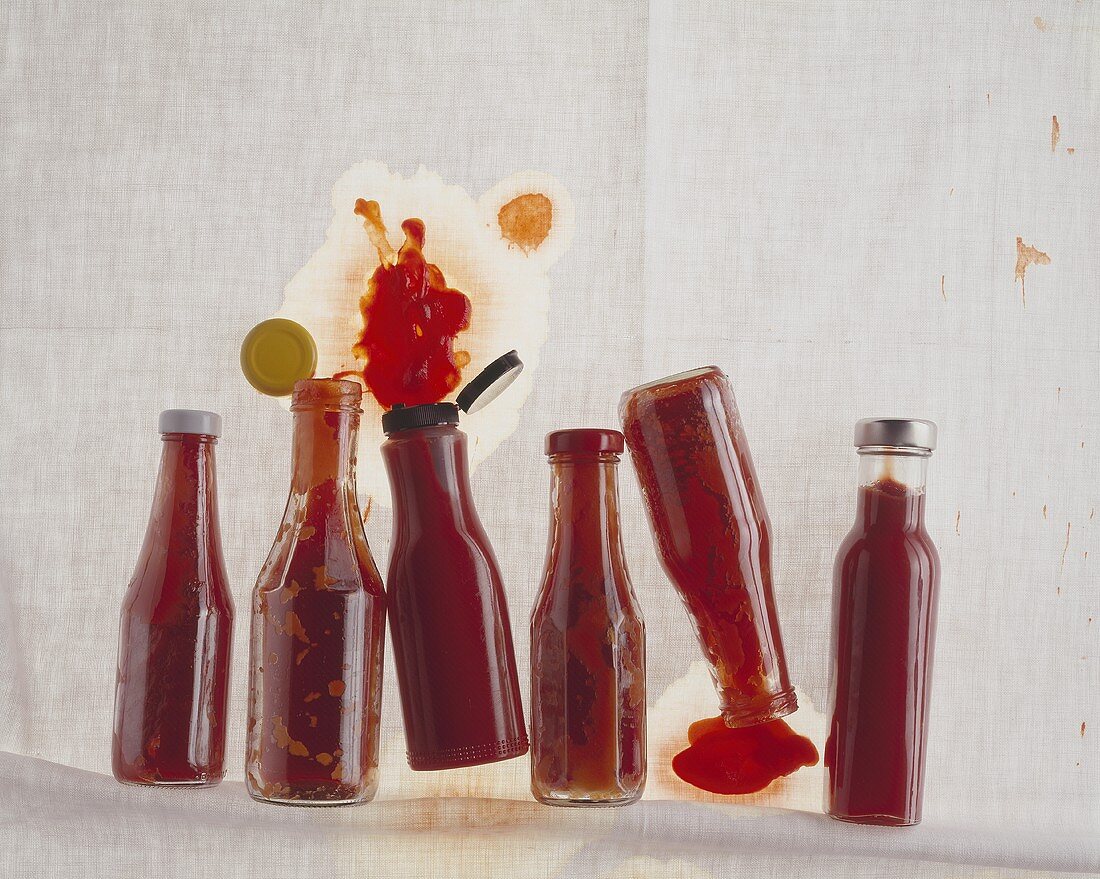 Mehrere geschlossene und geöffnete, liegende Ketchupflaschen