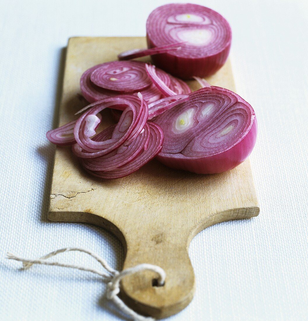 Partly sliced red onion on a chopping board