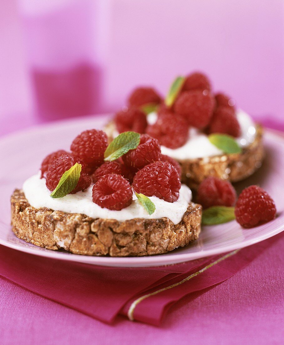 Wholemeal biscuits topped with yoghurt and fresh raspberries
