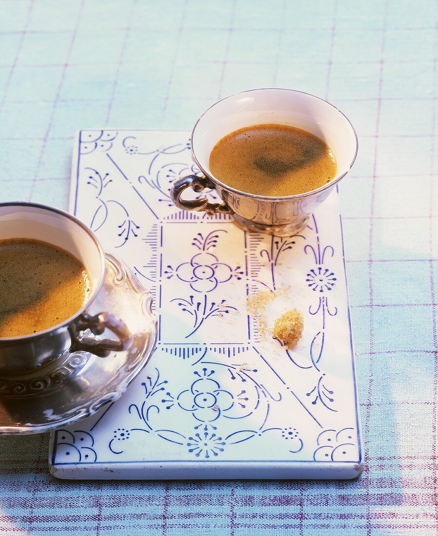 Espresso in zwei alten Mokkatasse auf Porzellan-Brettchen