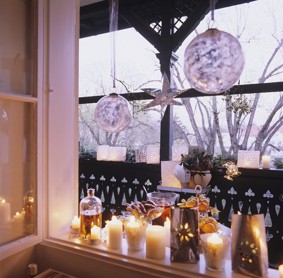 Weihnachtliche Kerzendeko am Fenster und auf dem Balkon