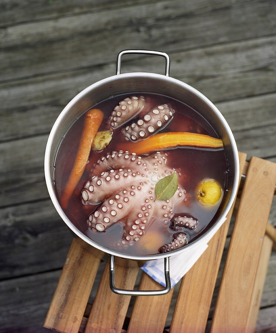 Octopus cooling in a pan of cooking liquid