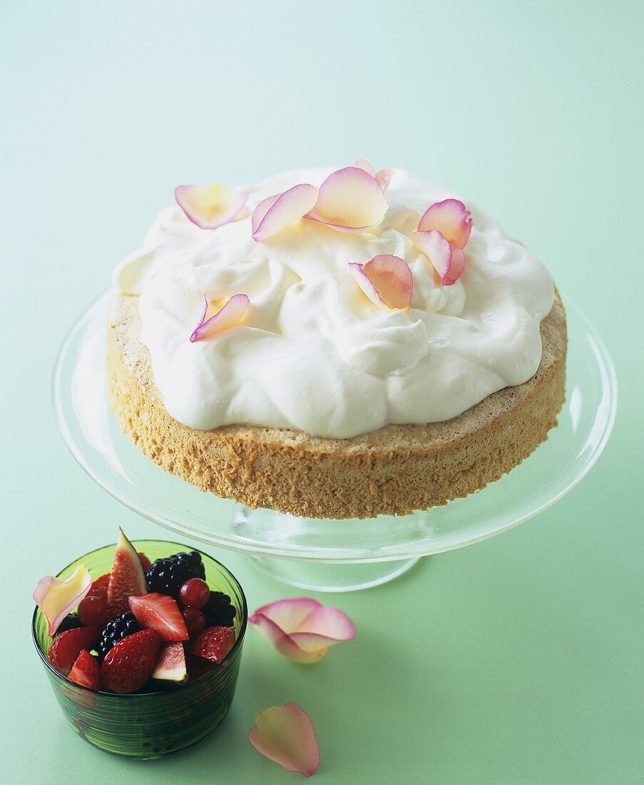 Biskuitkuchen mit Schlagsahne, Rosenblättern und Fruchtsalat