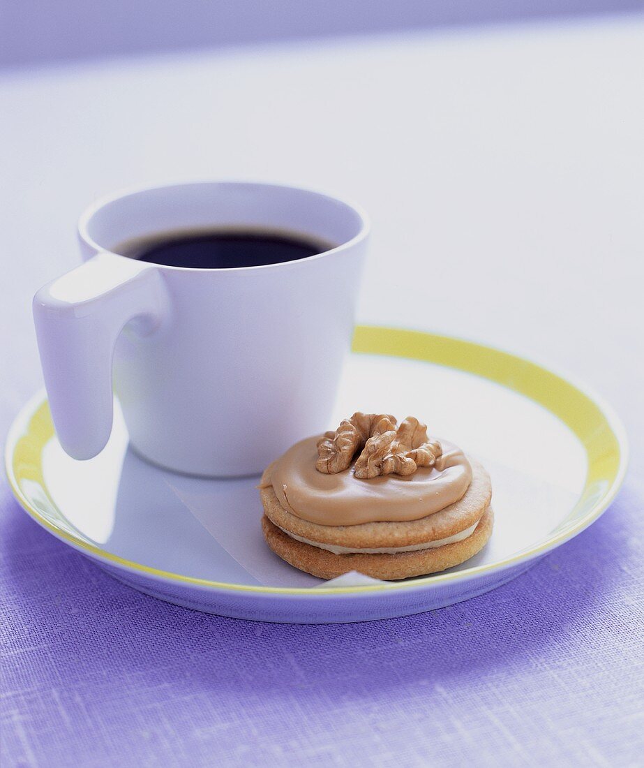 Eine Tasse Kaffe mit einem Walnuss-Keks