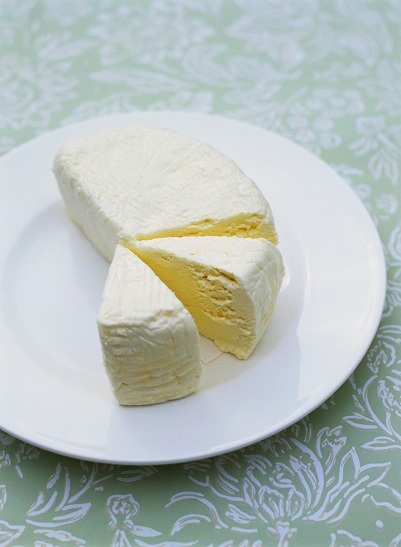 Soft cheese, two pieces cut, on a plate