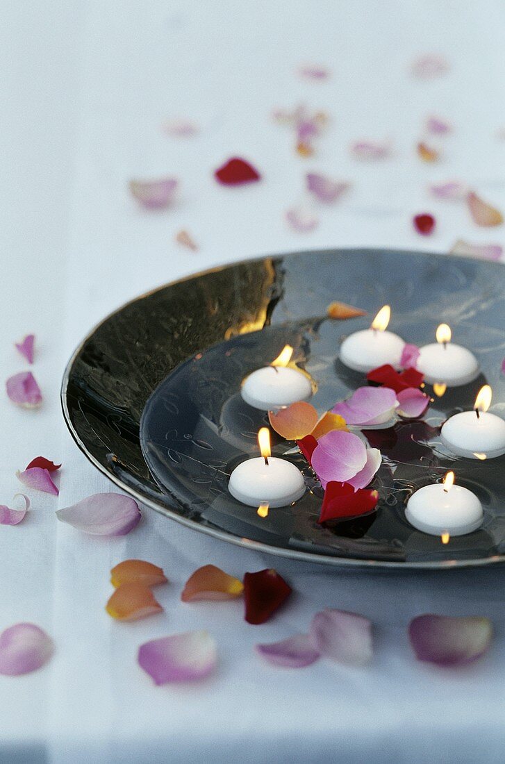 Floating candles and rose petals in a bowl