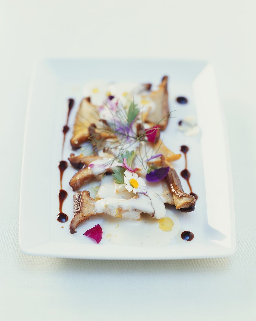 Fried king trumpet mushrooms with a truffle cream sauce and edible flowers