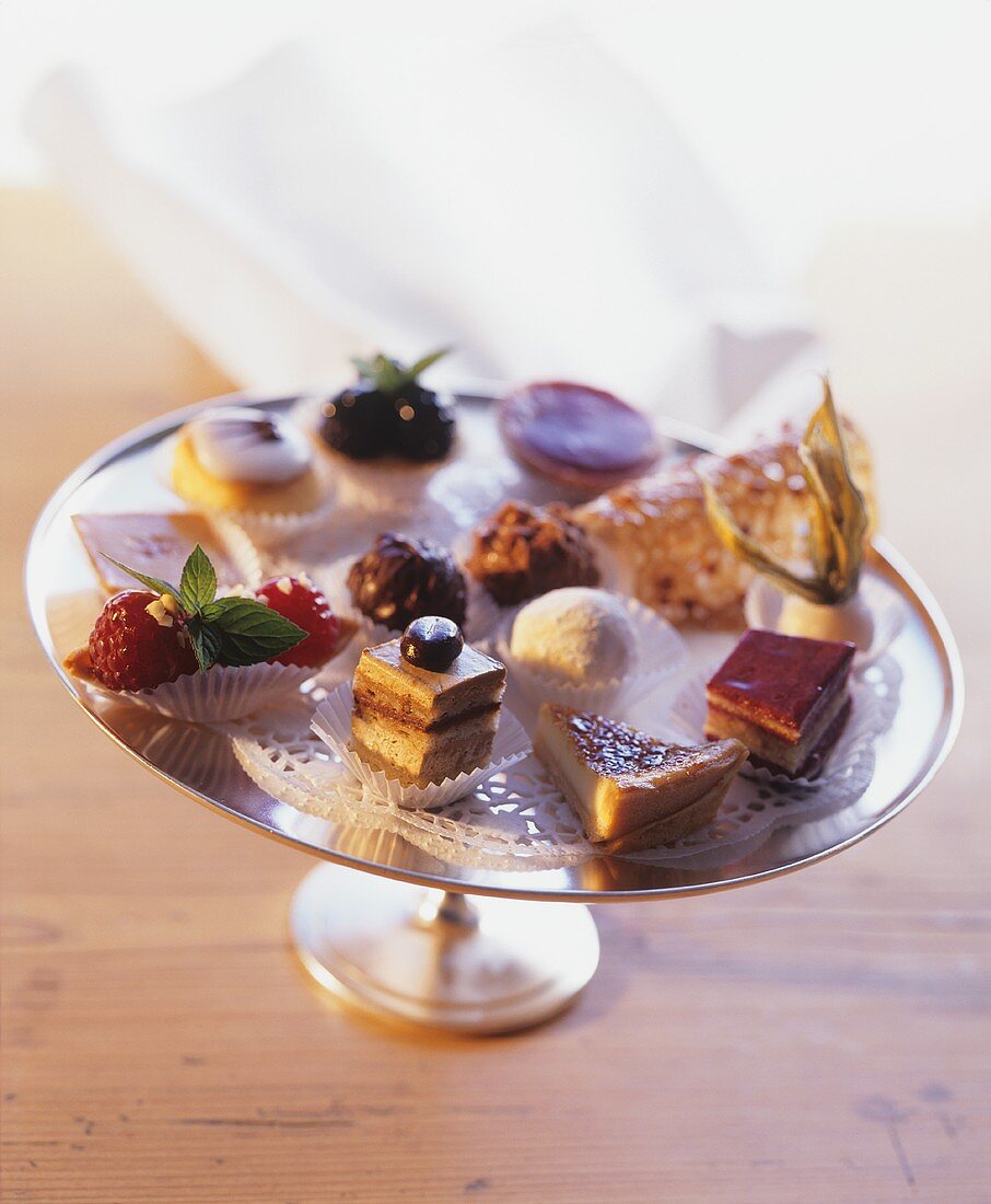 Sweets, chocolates and small cakes on a cake stand