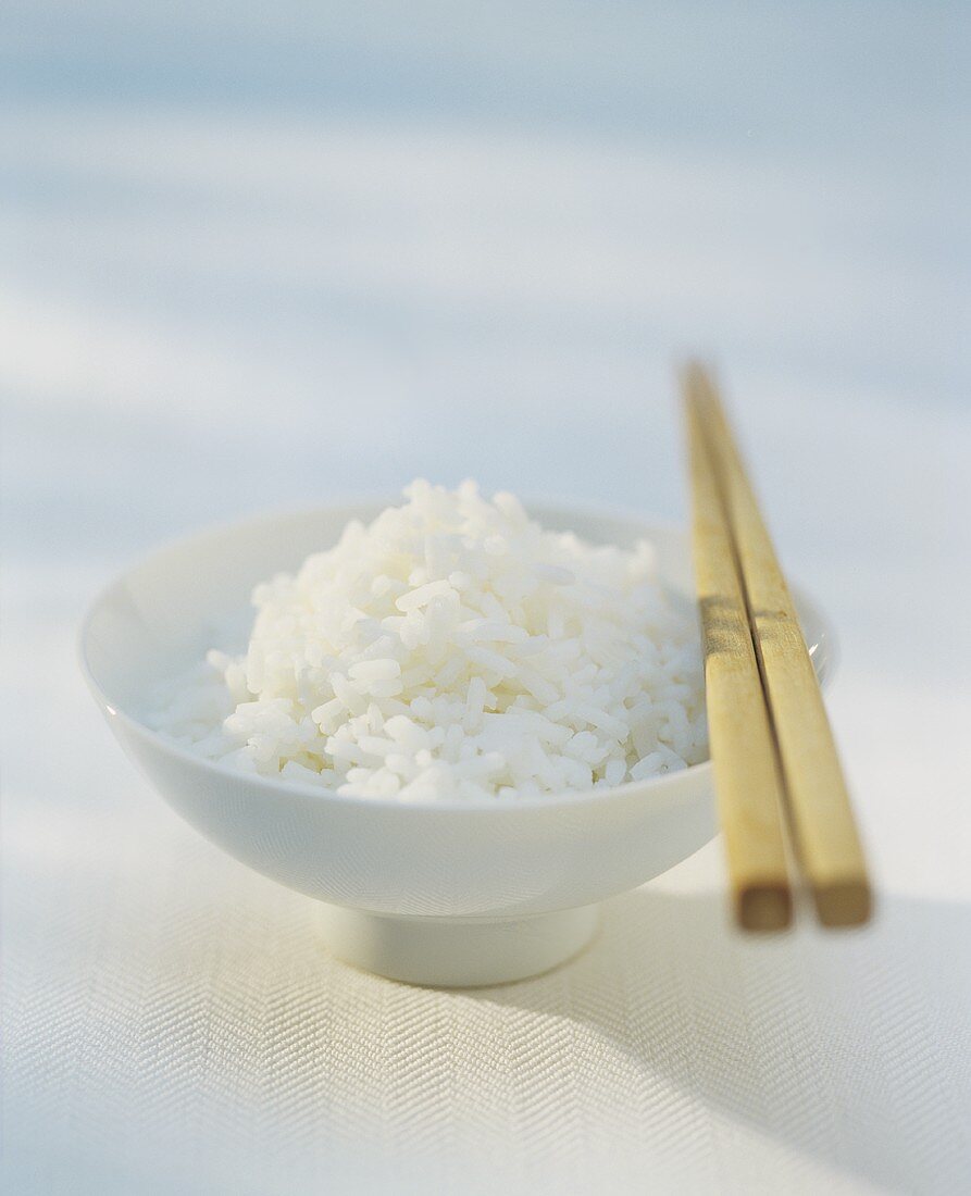 A bowl of rice with chopsticks