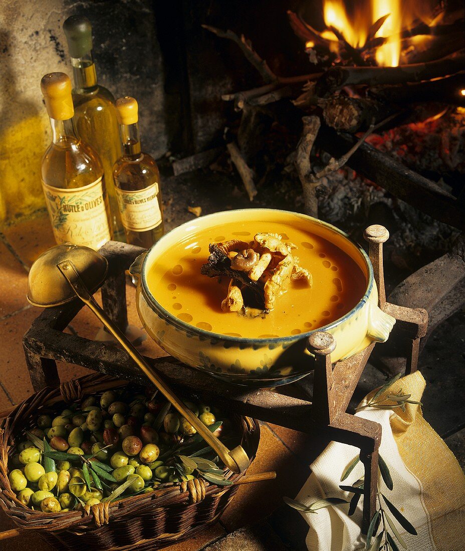Cream of pumpkin soup with wild mushrooms in front of a fire