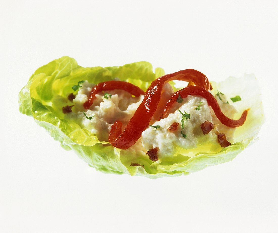 Cheese spread and red pepper on lettuce leaf