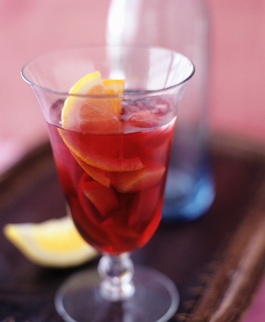 A glass of sangria with lemon