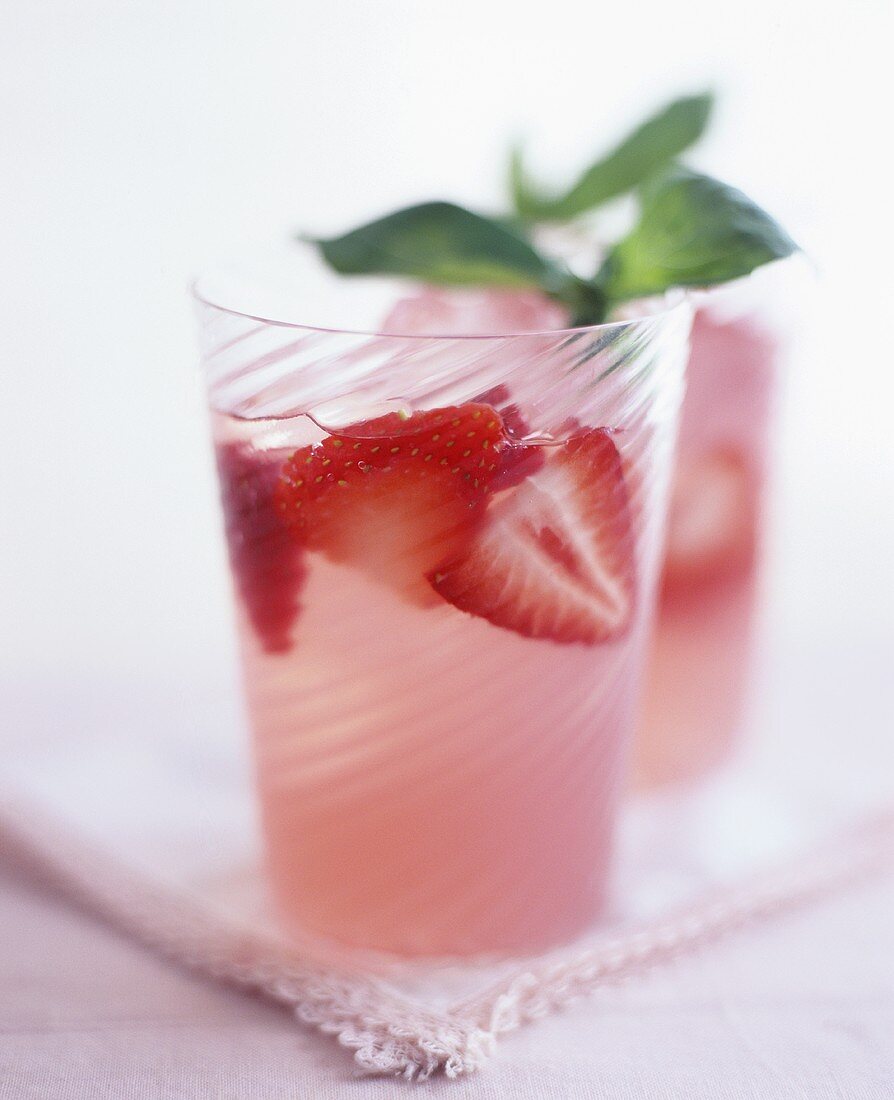 Zwei Gläser Erdbeer-Cocktail mit Limonade und Basilikum