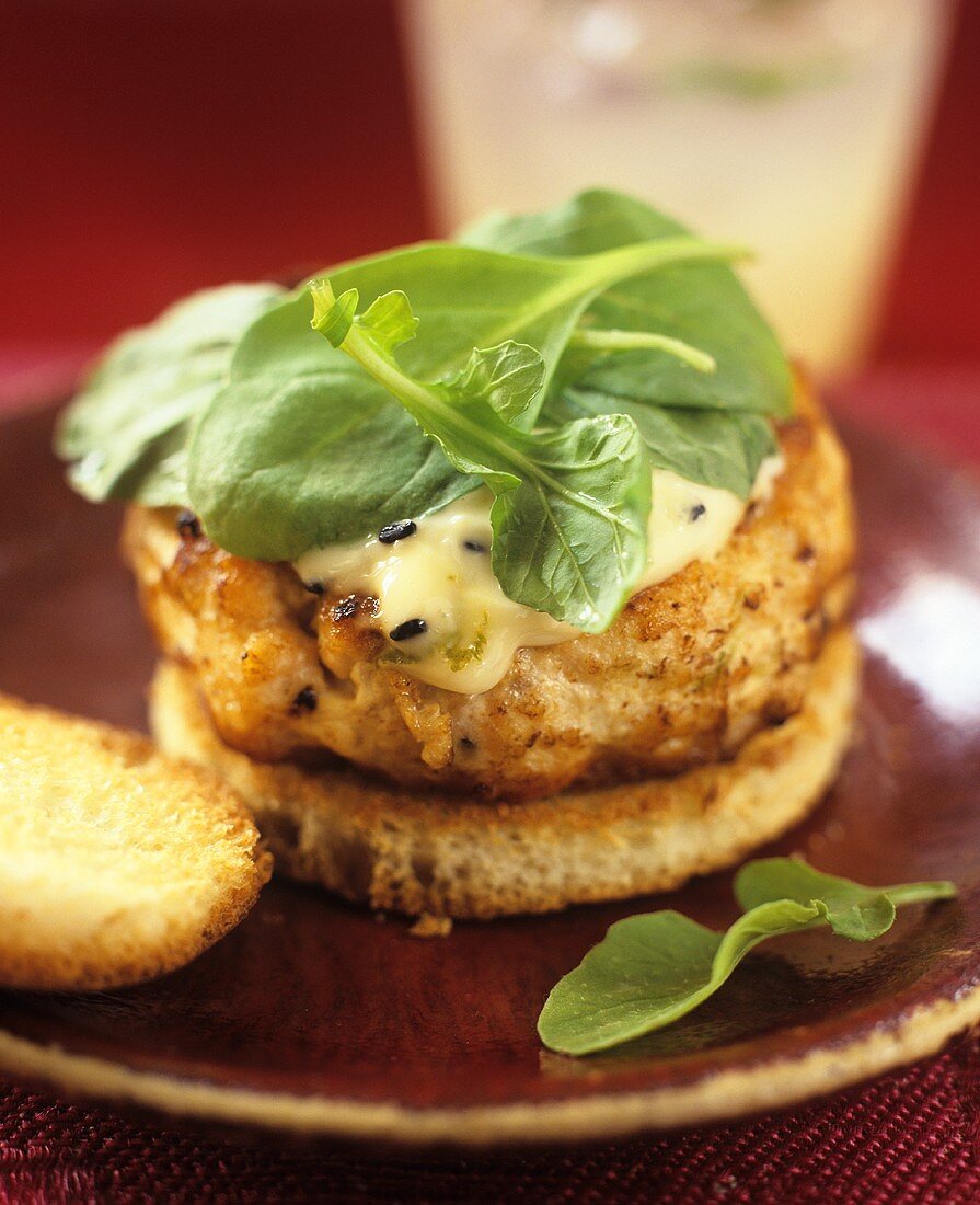 Salmon burger with lime mayonnaise and spinach leaves