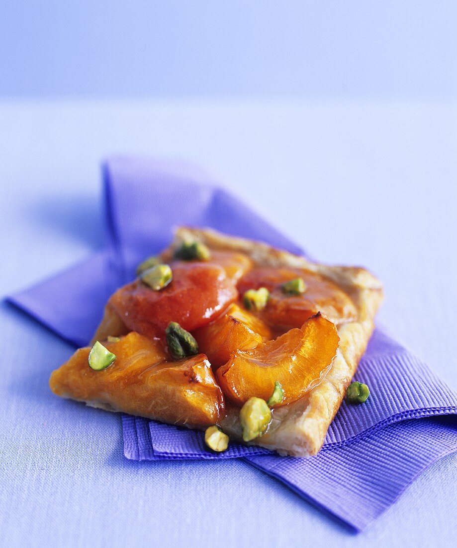A piece of apricot tart with pistachios