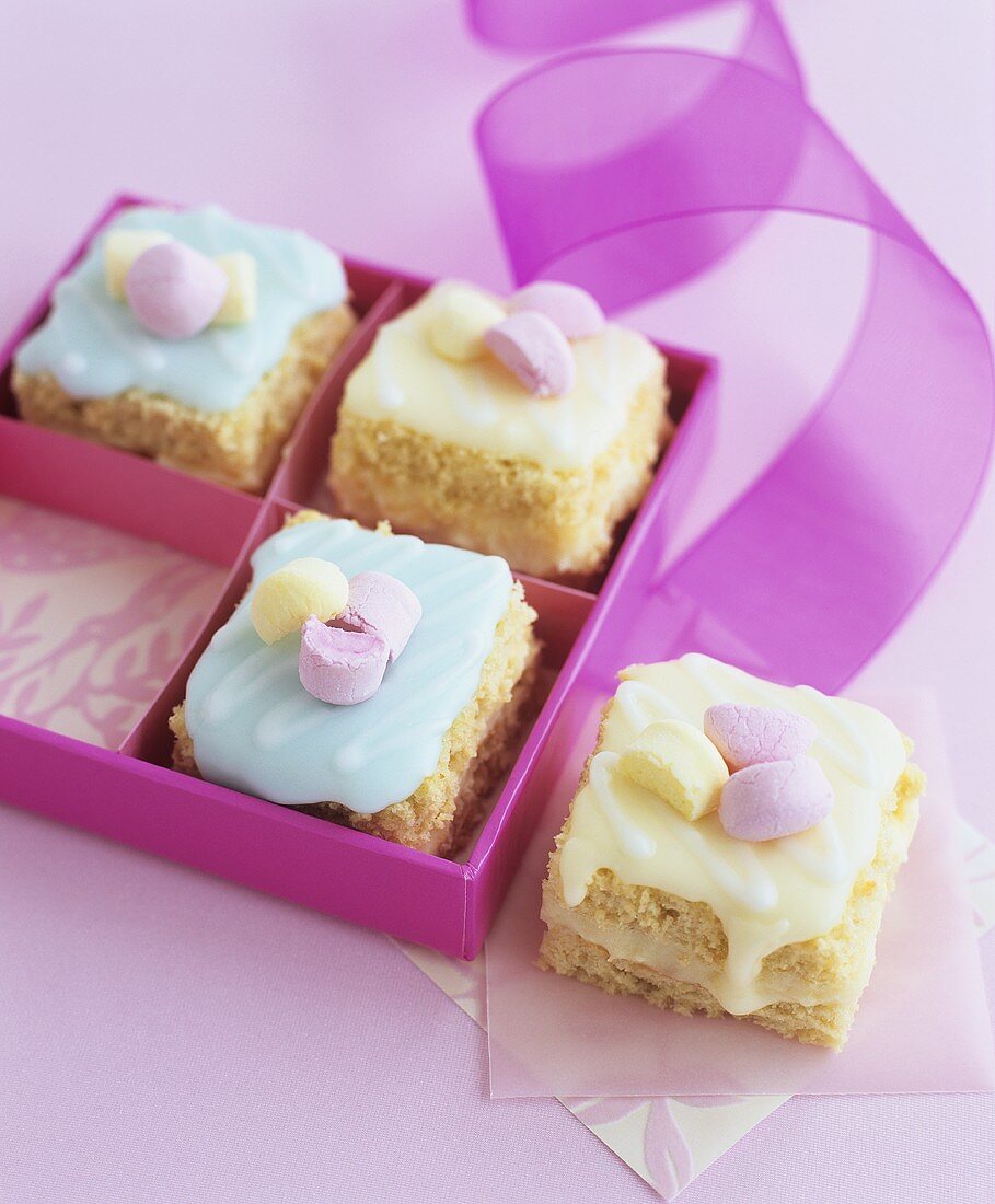 Minikuchen mit bunter Zuckerglasur mit Geschenkschachtel