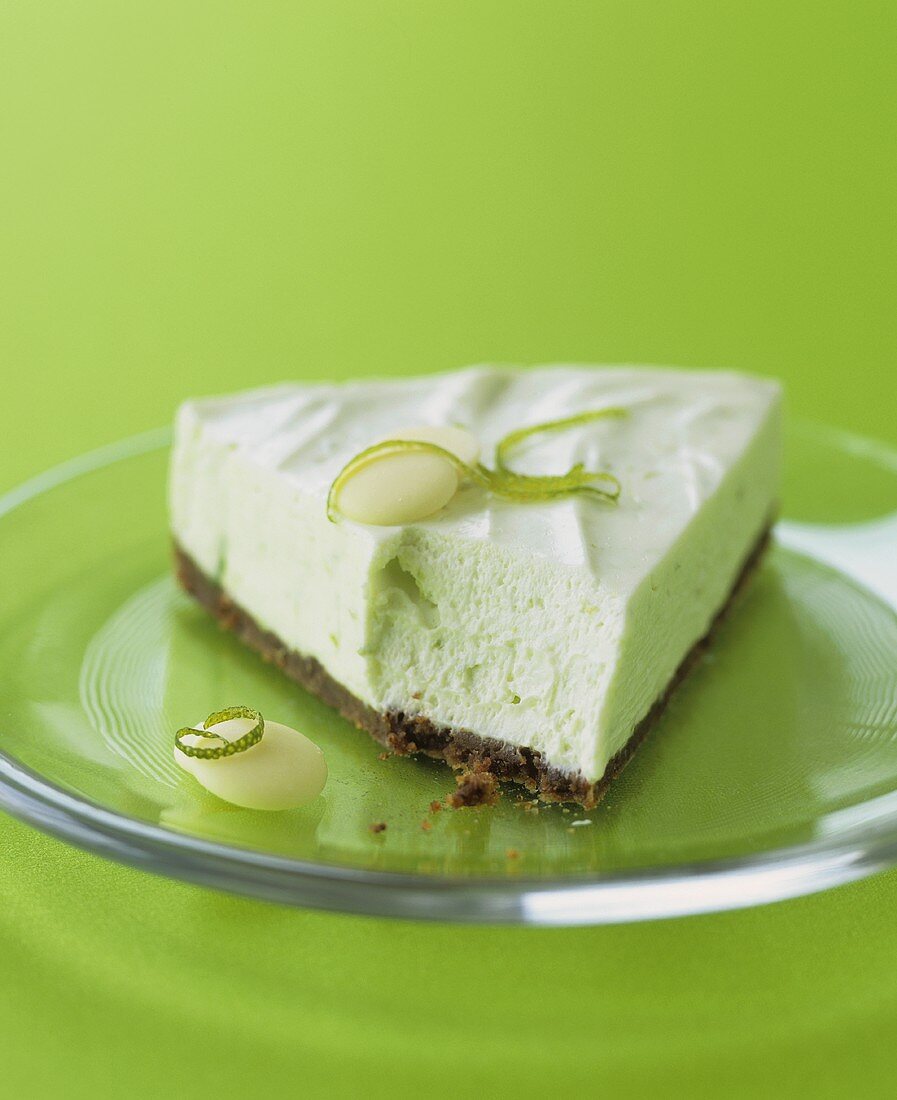 A piece of lime cheesecake with chocolate biscuit base