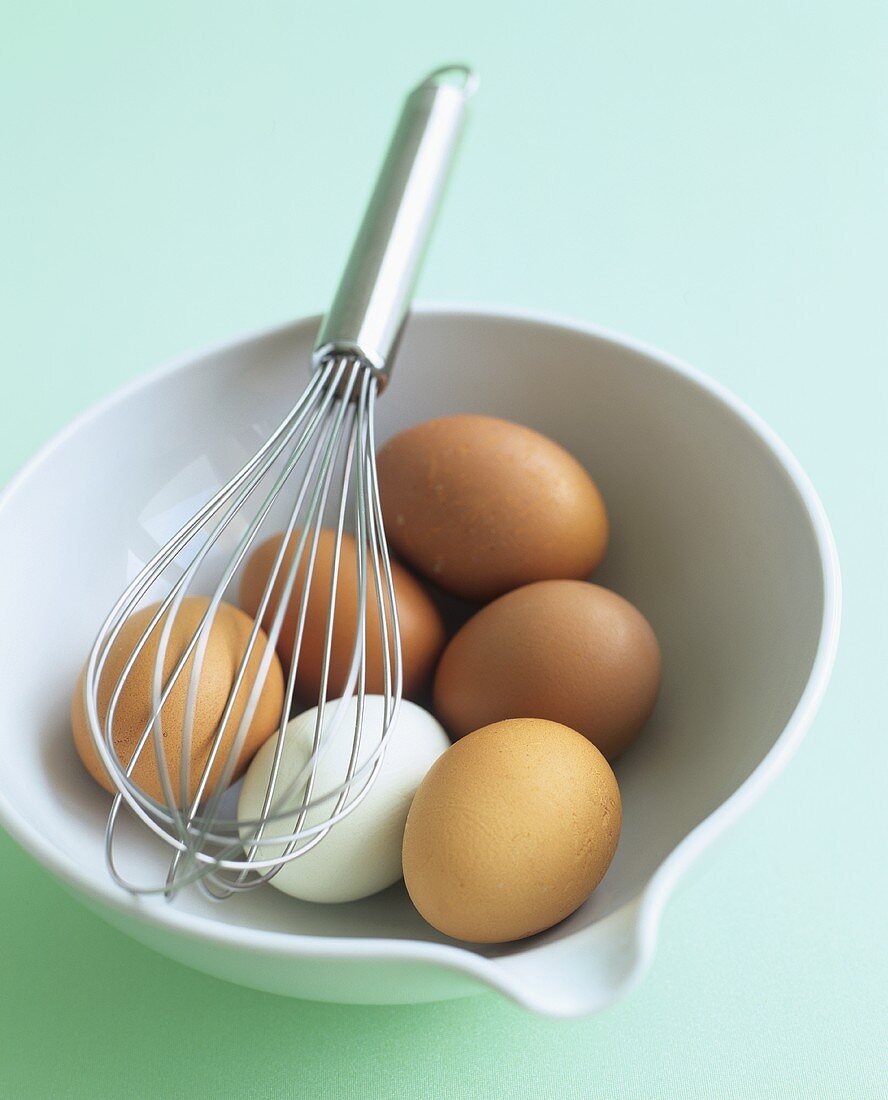 Eggs in a porcelain bowl with whisk