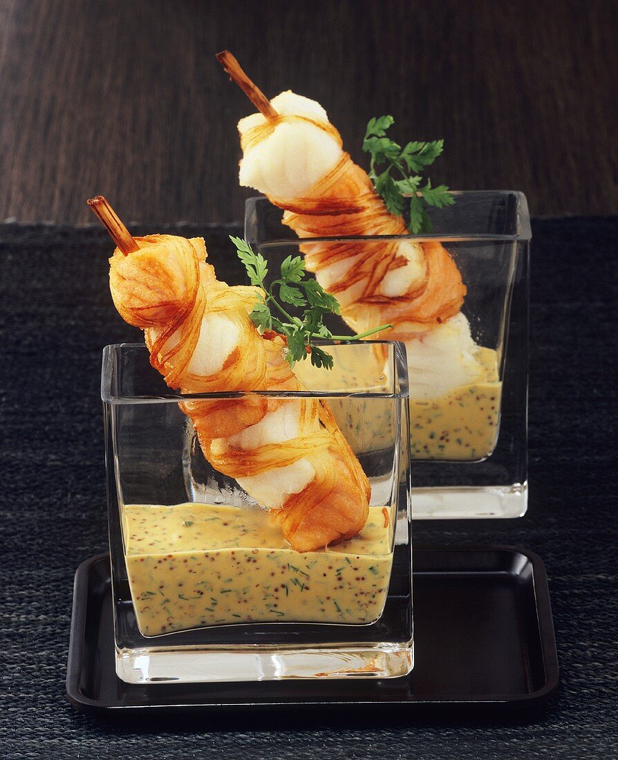 Fried fish kebabs with mustard sauce in glasses