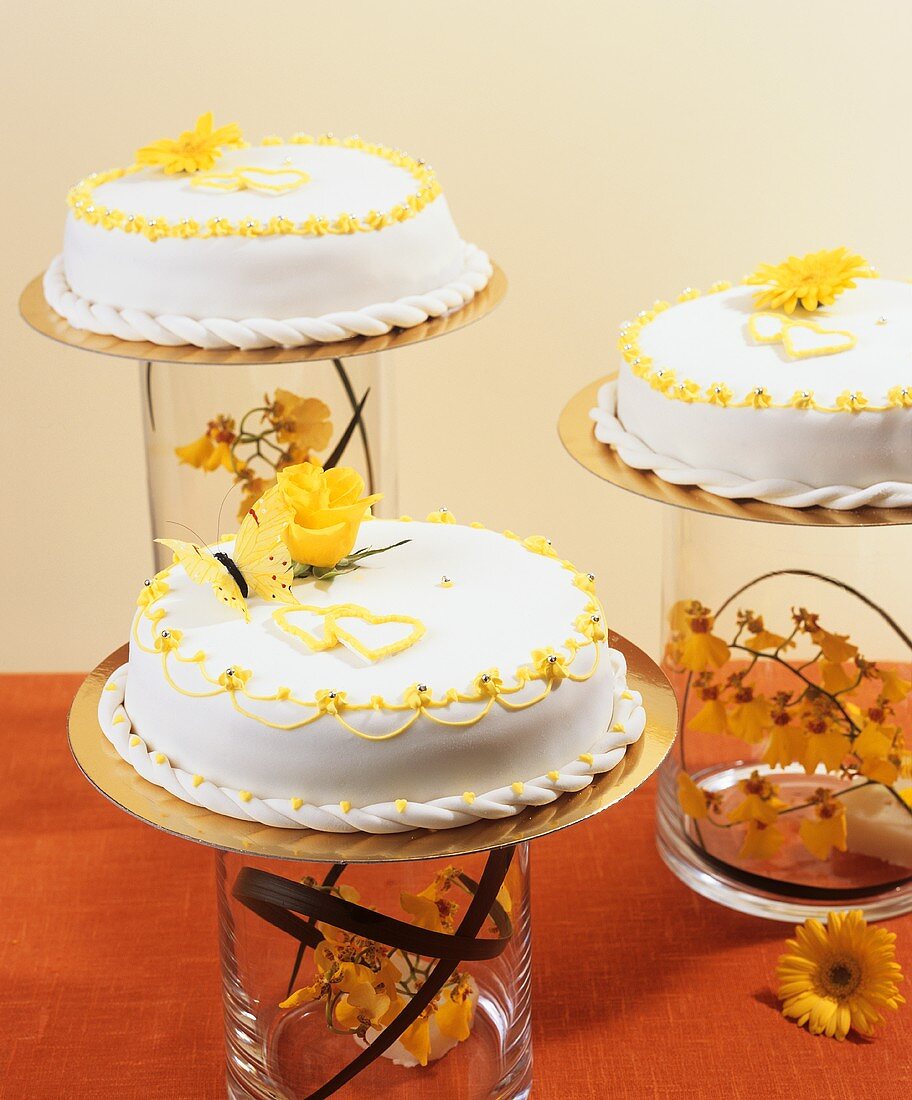 Three white cakes with fondant icing and springtime decorations