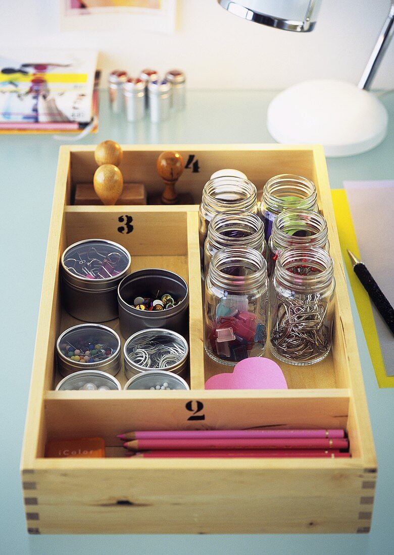 Office supplies in containers in cutlery box