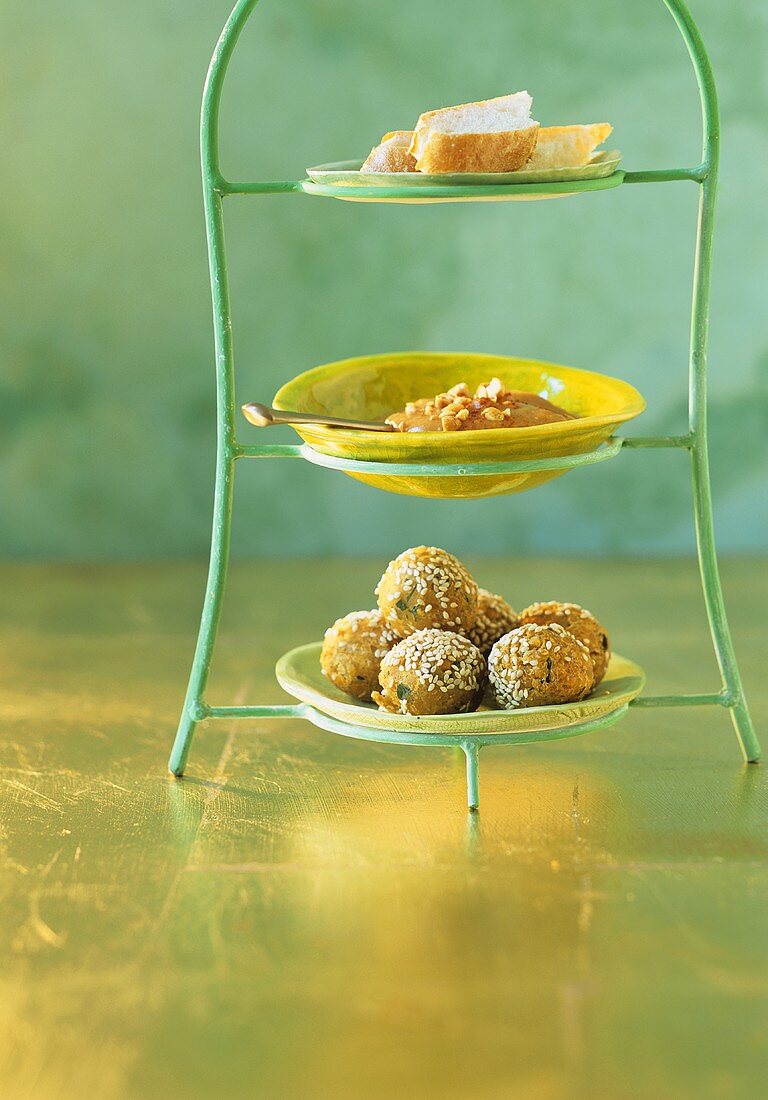 Etagere mit Linsenbällchen, Erdnussauce und Baguette