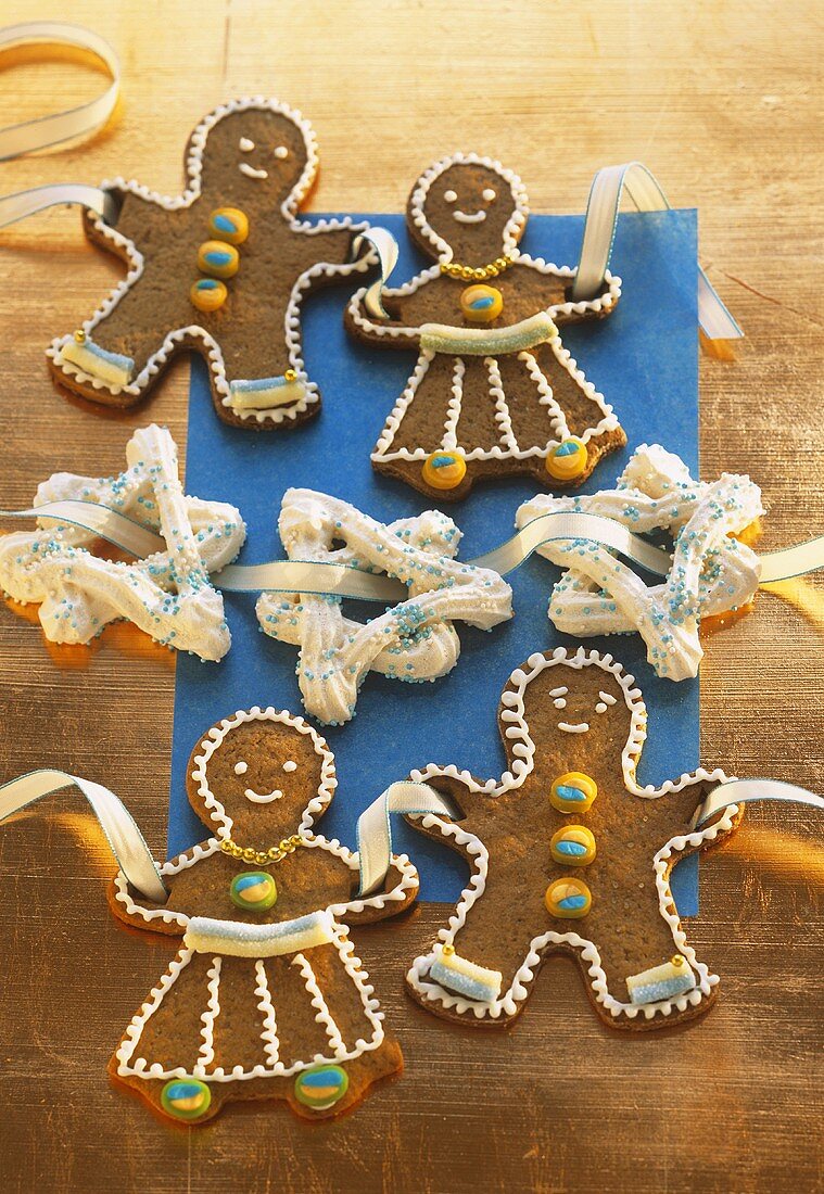 Gingerbread people and meringue stars threaded on ribbon